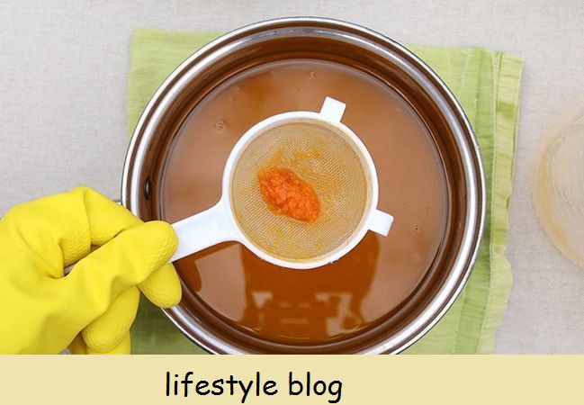 Como fazer sabão de cenoura usando cenouras reais: peneire a solução de soda cáustica enquanto a coloca nos óleos